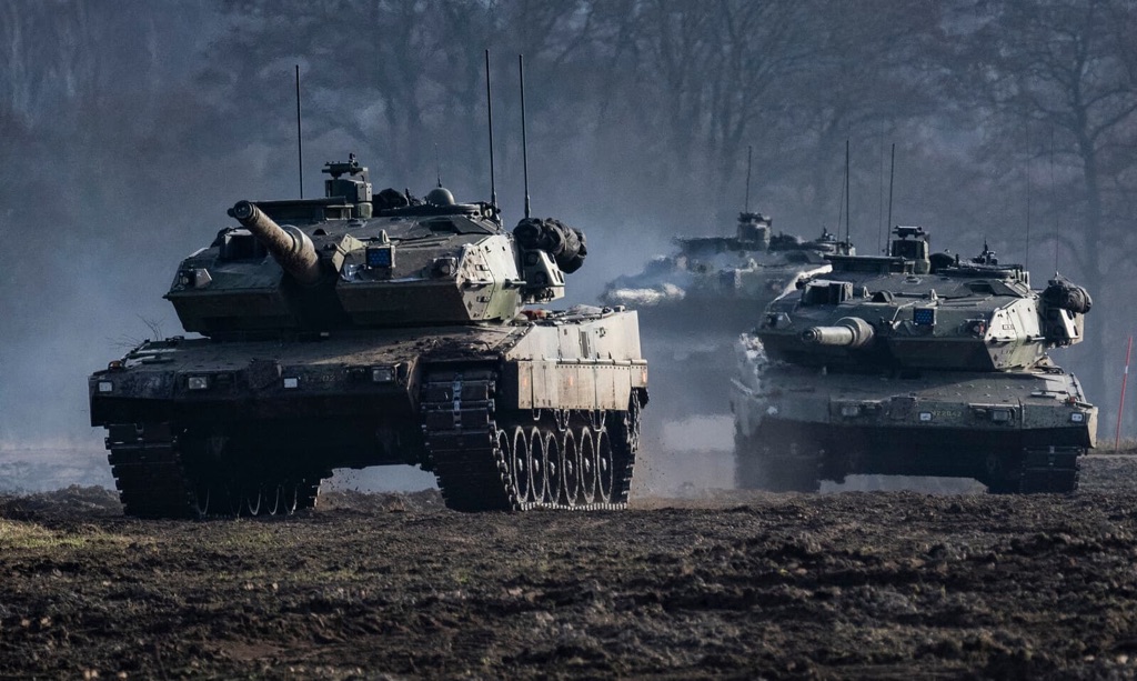 Three Stridsvagn 122 main battle tank systems in a muddy field on exercise maneuver
